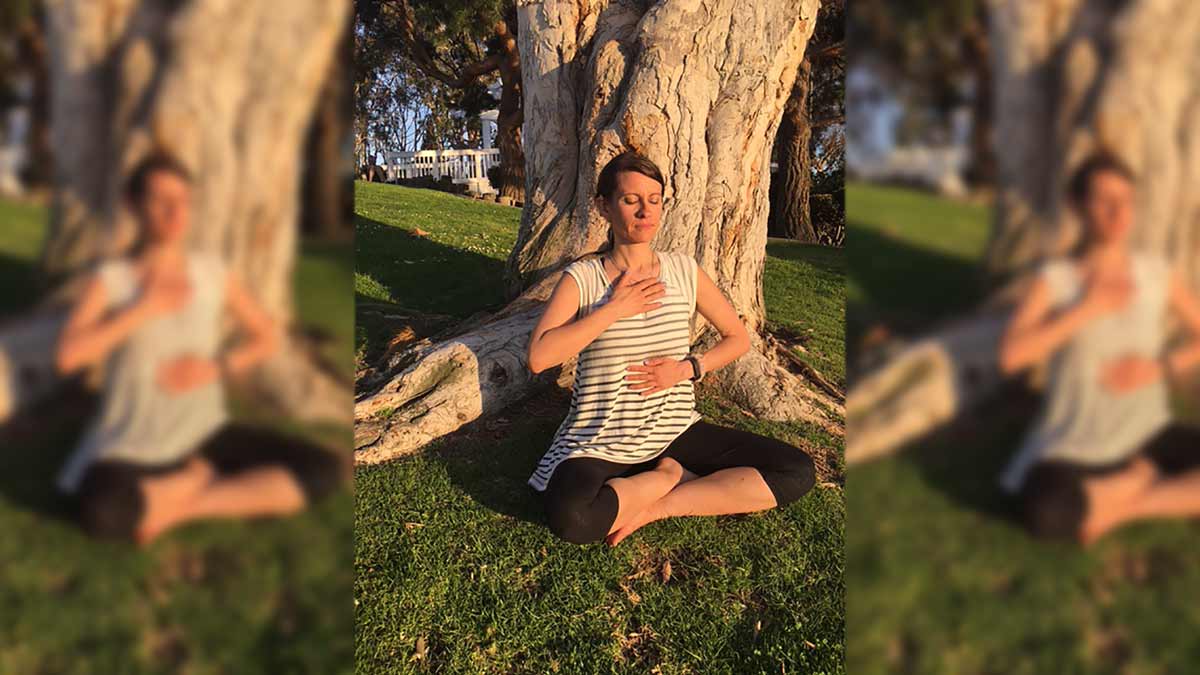 Photo of Jerry sitting by a tree in a park practicing Reiki Level 1