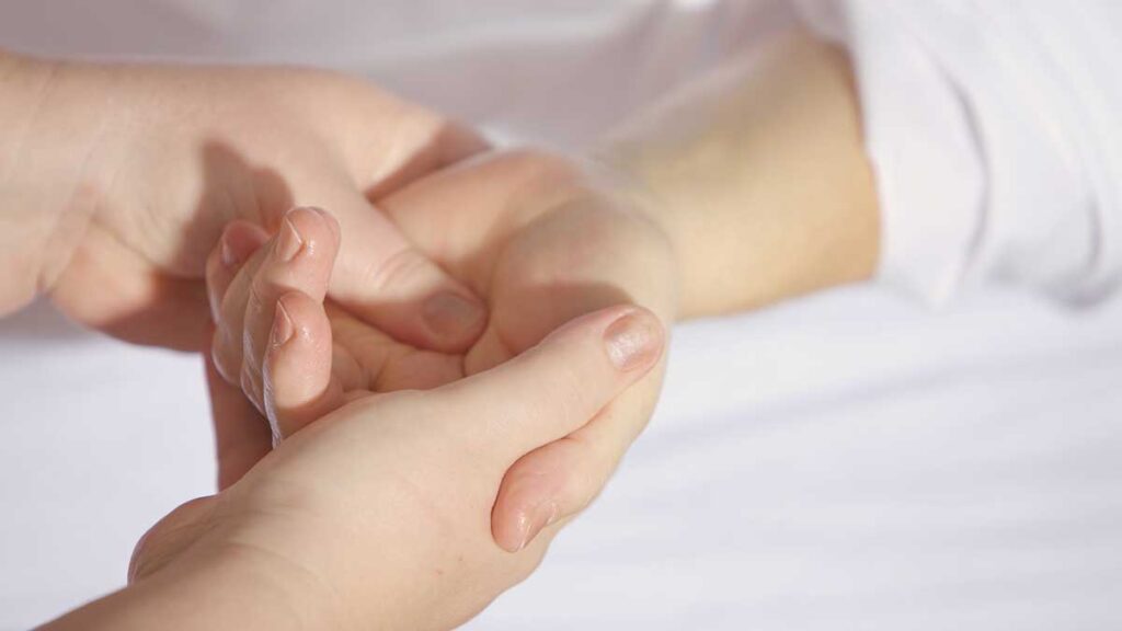 Jerry- Mikutis-Blog - Image of two hands holding another hand during a Reiki session - Reiki in Chicago